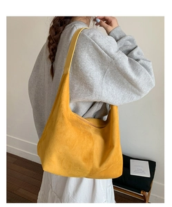 Detail of soft yellow suede large hobo bag showing texture and shoulder strap fit