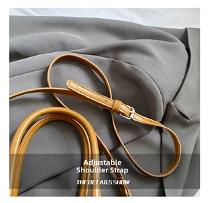 Details des verstellbaren Schultergurts und Griffs der braunen Leder-Eimertasche