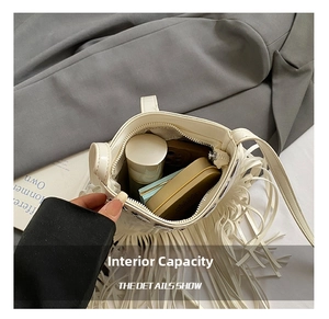 Top view of white fringe bucket bag showing internal capacity with phone and makeup