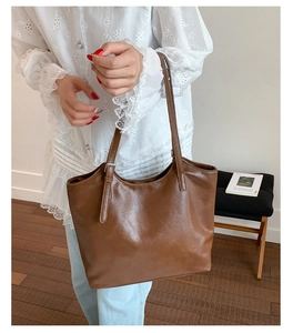 Detail view of adjustable strap and smooth texture on a vintage brown tote bag