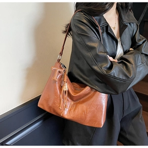Detail of vintage brown large tote bag with FASHION embossing and T-shaped leather charm