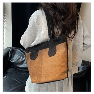 Detail shot of a matte suede patchwork tote bag on shoulder for urban styling
