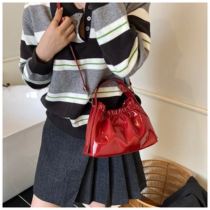 Detalle del bolso nube de charol rojo con acabado brillante y herrajes plateados