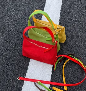 Detailed view of colorful suede dumpling bags in red, green and yellow with gold hardware