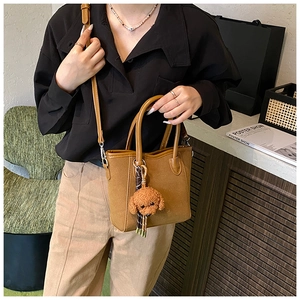 Detailansicht der stilvollen braunen Tasche mit Anhänger, ideale Freizeittasche für den Alltag.