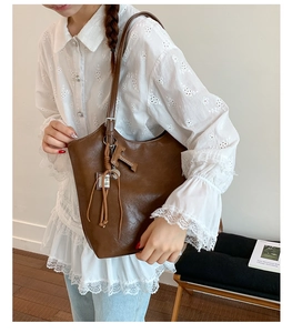 Detail of vintage brown leather tote bag with stylish long tassel and metal hardware