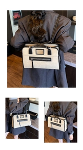 Detail of a large cream and black bicolor leather backpack showing texture and zip closure