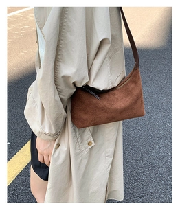 Detailed view of a vintage brown suede crossbody bag styled as an everyday shoulder bag