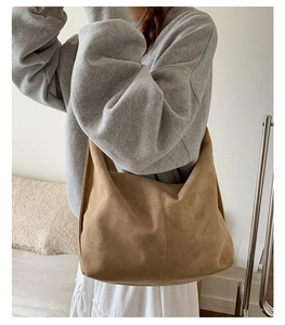 Detailed close-up of brown suede hobo tote bag showing soft matte texture and wide strap