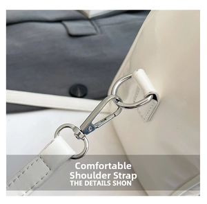 Detail of silver metal hook and stitching on white punk rivet bucket bag shoulder strap