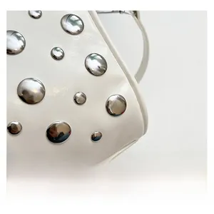 Detailed macro view of white leather texture and polished silver metal stud rivets