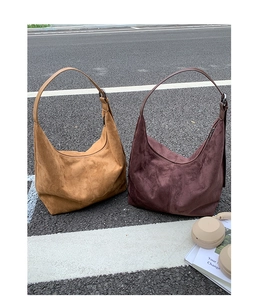 Detailed texture of suede hobo bags in camel and dark brown with adjustable straps