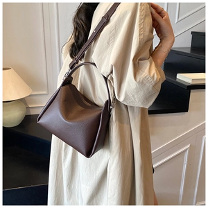 Detailed view of dark brown litchi pattern leather handbag with silver metal hardware
