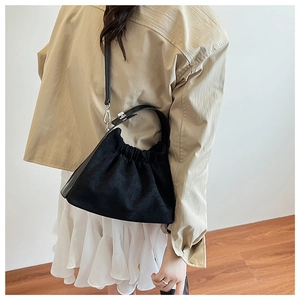 Détail d'un sac nuage noir plissé avec une texture douce et une bandoulière fine