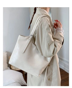Detail of soft cream white oversized tote bag with adjustable shoulder strap and silver buckle