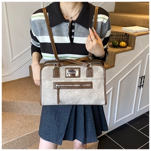 Close-up of marble texture grey handbag with brown trim and metallic zip detail