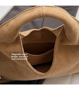 Detail view of the brown suede handbag showing magnetic buckle and internal side pocket