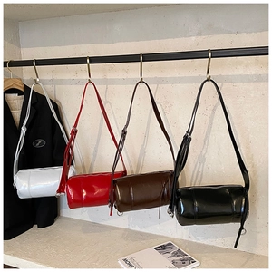 Detail view of four minimalist vintage cylinder bags in white, red, brown and black leather