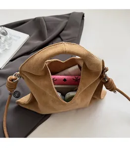 Top view of brown suede handbag interior showing spacious storage and knotted strap detail