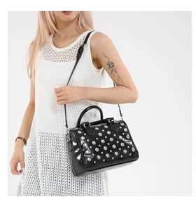 Close-up of black punk rivet Boston bag with silver studs and polished leather finish