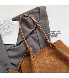 Detail view of the brown suede tote bag featuring unique knotted leather shoulder straps