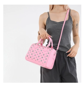 Close-up of pink patent leather handbag featuring dense silver rivet stud embellishments