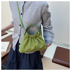 Détail du sac nuage en daim vert montrant la texture froncée et la bandoulière réglable
