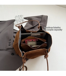 Macro view of brown suede tote bag interior showing large capacity and inner pouch