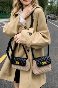 Close-up of quilted crossbody bag with brown suede finish and metallic twist lock