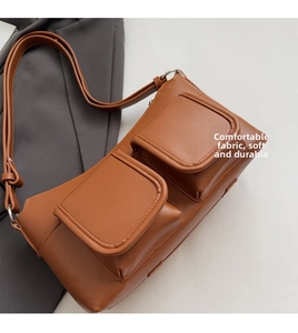 Detailed view of brown PU leather shoulder bag featuring dual front flap pockets and straps