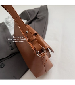 Detailed macro view of caramel brown pebbled leather texture and silver metal ring hardware
