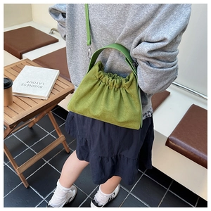 Détail du sac nuage vert herbe avec design plissé et finitions en métal argenté