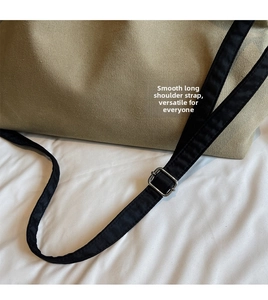 Detail of adjustable black shoulder strap with silver buckle on canvas tote bag