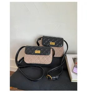 Detail of vintage quilted crossbody bags with khaki suede and gold twist lock closure