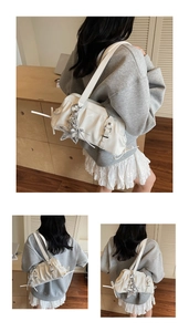 White glossy pleated underarm bag with silver star charm and drawstring detail on strap