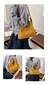 Detail of a bright yellow suede handbag featuring a unique V-shaped opening and knotted strap