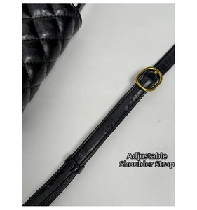 Close-up of adjustable leather shoulder strap with gold metal buckle on quilted bag