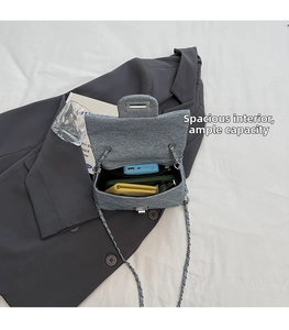 Spacious interior of gray textured flap bag showing storage for phone and wallet