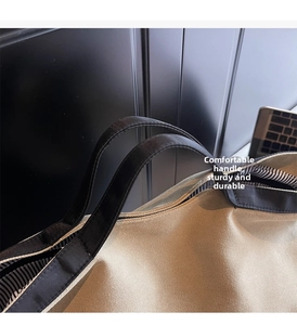 Detail of sturdy handle stitching and striped lining on a canvas tote bag