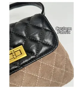 Detail of quilted leather handbag with gold twist lock and contrast stitching