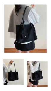 Detail view of black matte tote bag featuring knotted shoulder straps and mini pouch