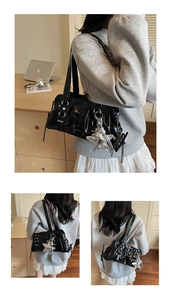 Detail of glossy black shoulder bag featuring pleated texture and silver star charm