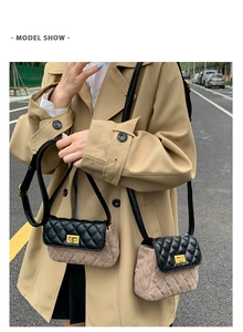 Outdoor street style view of a quilted color-block crossbody bag with gold turn-lock