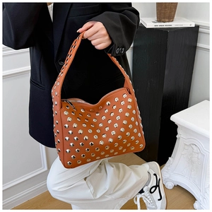 Detail of retro brown leather shoulder bag with silver rivet studs and metal zipper