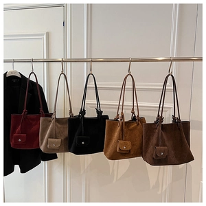 Detailed close-up of matte suede tote bags in five earthy colors with matching mini pouches