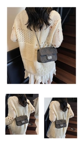 Detail of dark grey quilted crossbody bag with metal twist lock and chain strap