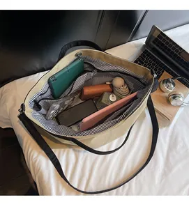 Detailed interior of a large canvas tote bag with striped lining and magnetic closure