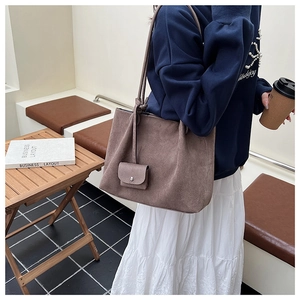 Close-up of vintage matte tote bag and mini pouch in a casual urban setting