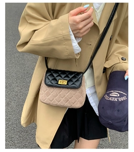 Detailed view of two-tone quilted crossbody bag with golden twist lock and mixed textures