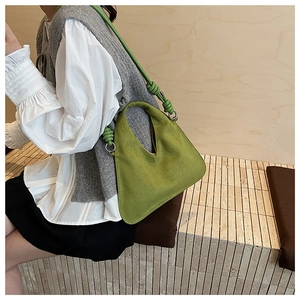 Detail of avocado green frosted leather bag featuring unique V-cut and knot design